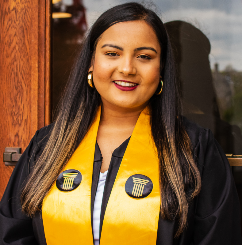 Image of Abina Baral wearing her Stamps Scholar graduation gown