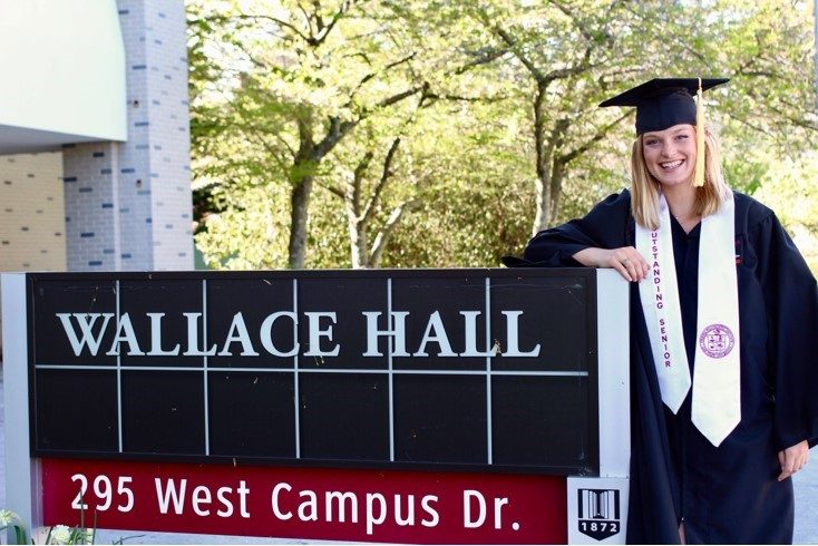 Caitlin Bowman standing next to Wallace Hall