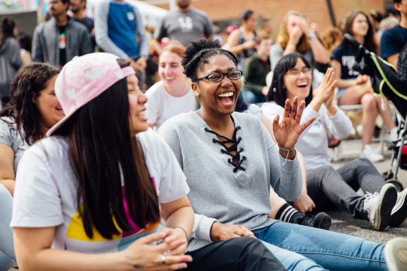 Students sitting and laughing at a campus event